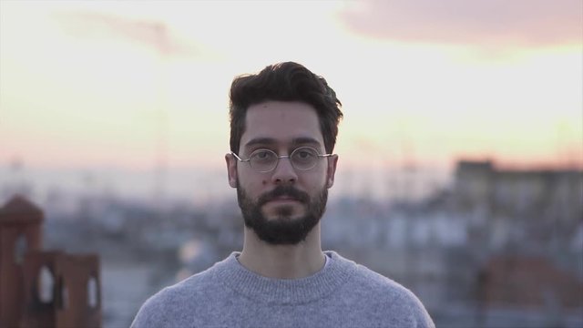 Attractive Young Man Walking Towards Camera,  On Rooftop of a building at Sunset Time,  Slow Motion Shot with Gimbal, Close up