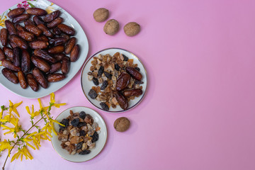 Fototapeta na wymiar bowl of mixed dry fruits and nuts on pink table