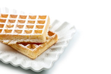 Belgium waffers with sugar powder on ceramic plate isolated on white background.