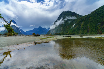 Naklejka na ściany i meble reflections of mountains in the water, milford sound, new zealand 8