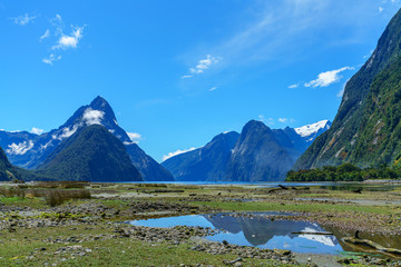 Naklejka na ściany i meble reflections of mountains in the water, milford sound, new zealand 11