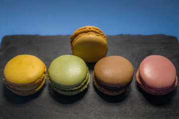 MACARONS ON BLACK SLATE AND BLUE BACKGROUND