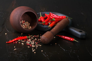 Wooden mortar for spices, spicy red peppers and pepper peas.