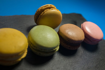 MACARONS ON BLACK SLATE AND BLUE BACKGROUND