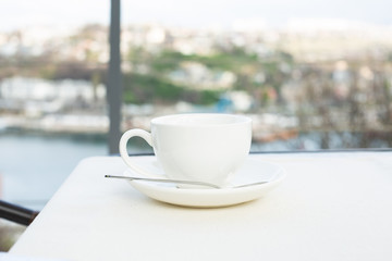 White ceramic cup with saucer on the table outdoor