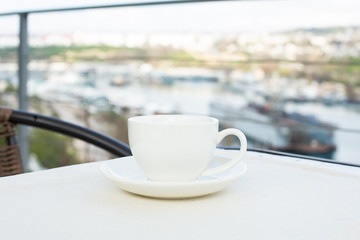 White ceramic cup with saucer on the table outdoor