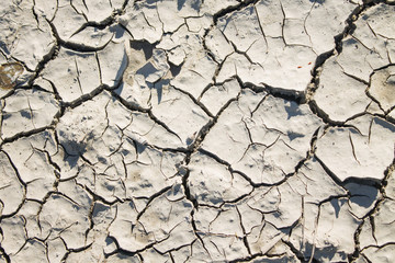 texture of dry cracked grey clay with sun shade