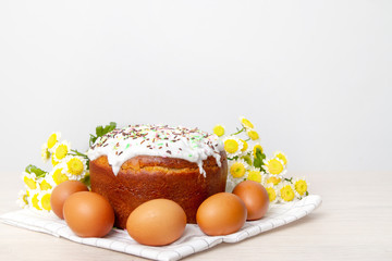 Easter cake and colored eggs yellow flower blossoms on background. Holiday food and easter concept. Selective focus. Copyspase