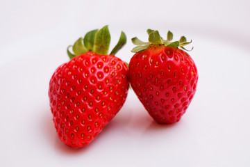 Berries of juicy fresh tasty strawberries on a white table