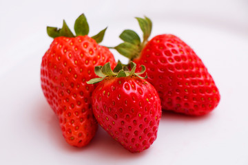 Berries of juicy fresh tasty strawberries on a white table