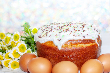 Easter cake and colored eggs yellow flower blossoms on background. Holiday food and easter concept....