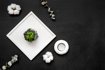 modern design of work desk with plant, candle on black background top view copy space