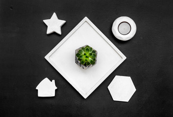 modern design of work desk with candle, star figures on black background top view