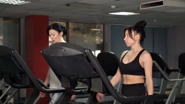 Young women is suitable to do running exercises in the gym on the treadmill.