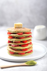 Homemade matcha Pancakes with strawberries and Butter. Ready for breakfast.