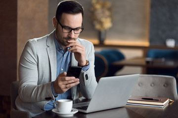 Young businessman reading a text message on smart phone.