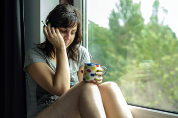 Mujer morena sentada en ventana 13