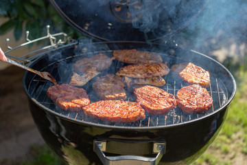 steaks cooking over flaming grill