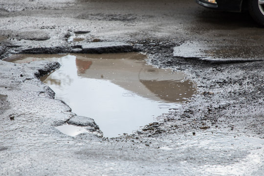 Pothole In Pavement Signifying Failing Infrastructure. Pathole On The Road.