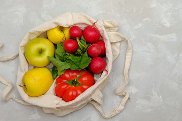 Cotton shopping bag with vegetables on grey bakground, zero waste concept. Image with copy space, flay lay.