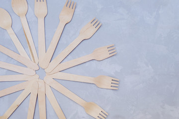 Zero waste concept. Wooden spoons and forks on grey background. Image with copy space, top view.