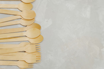Zero waste concept. Wooden spoons and forks on neutral background, copy space, top view.