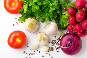 Young garlic, tomato, parsley, cucumber, radish and pepper on a clean white surface