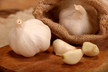 Garlic. sliced garlic, garlic clove, garlic bulb in wooden bowl place on chopping block on vintage wooden background.