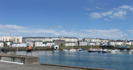 Naklejka premium Houses in the harbour by the irish sea Co. Antrim Northern Ireland 2017 with blue sky background for editors text copyaa