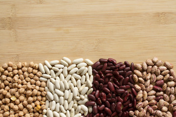 Legumes. Chickpeas, white navy beans, red beans and cranberry beans on wooden table.
