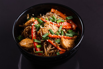 Buckwheat noodle in a black bowl on chicken fillet