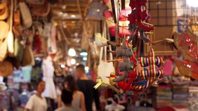 Soft toys, souvenir dragons or crocodiles waving on ropes at street market in Siem Reap, Cambodia