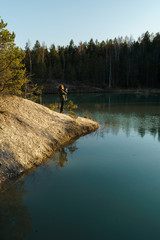 Young woman takes travel photos -Beautiful turquoise lake in Latvia - Meditirenian style colors in Baltic states - Lackroga ezers