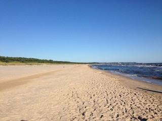 Beach sand and blue sky. Panoramic view of horizon