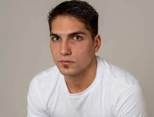 Fototapeta premium Natural portrait of young attractive man in his 20s looking and posing with neutral face expression