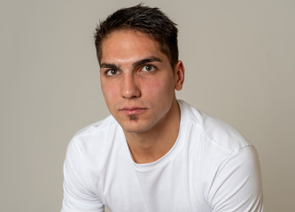 Obraz premium Natural portrait of young attractive man in his 20s looking and posing with neutral face expression