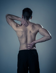 Body Pain. Strong young man suffering neck and back pain