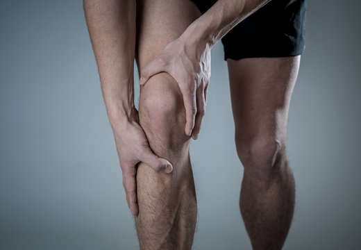 Sport Man Injured When Exercising Or Running Holding His Knee In Pain