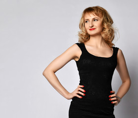 Fototapeta premium Young beautiful blonde woman in black little dress posing 