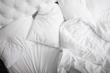View on top of crumpled bed with white linens. Make the bed. Used dirty bedding. Fresh sheets. Crumpled sheets. Bed after sleeping in the morning. Pillow and blanket. Concept. Close up. Copy space. - 263578034