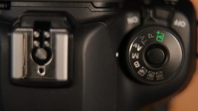 Womens hand turning on dslr camera. DSLR camera switches and buttons turned on.