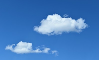 Naklejka na ściany i meble White puffy clouds on a beautiful summer day with a pretty blue sky.