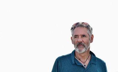 Handsome, interesting, healthy looking older man looking into the distance with optimistic expression on high key background. 