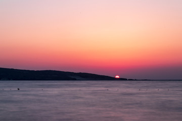 a long exposure wide landscape shoot of sea at sunset with good colors
