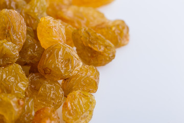 golden raisins on a white acrylic background
