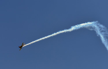 Single one sport plane of aerobatic team vapour trails in blue sky. Plane white vapour trails tracks background. Plane aerobatic maneuver stunt. Budapest, Hungary.
