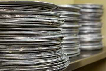 Greased pizza pans in a restaurant kitchen