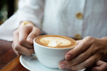 People are drinking a latte in a coffee shop.
