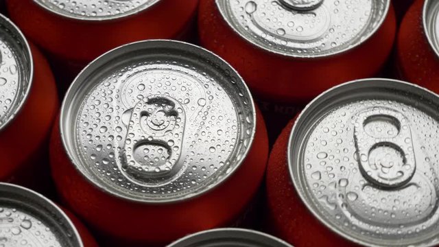 top view water droplets on red can of soda or beer rotate background. Slow motion video dolly crane shot medium extreme close up panorama high angle telephoto lens
