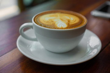 People are drinking a latte in a coffee shop.
